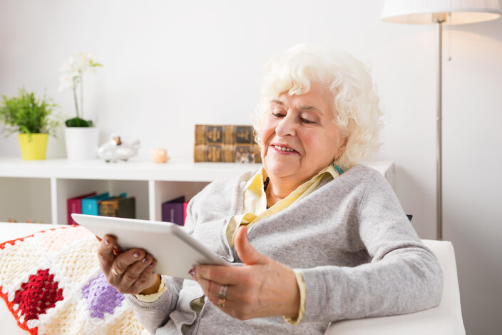 Senior using Ipad in her livingroom